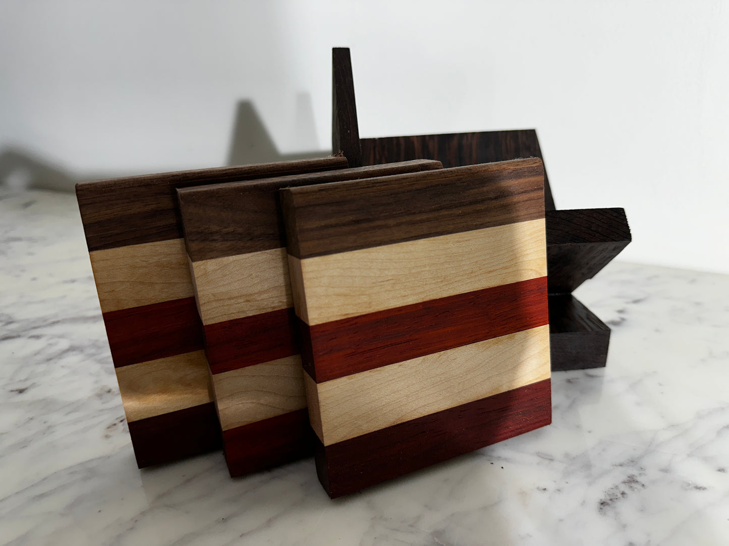 set of 3 Walnut, Paduak and Maple Coasters with modern Wenge Stand